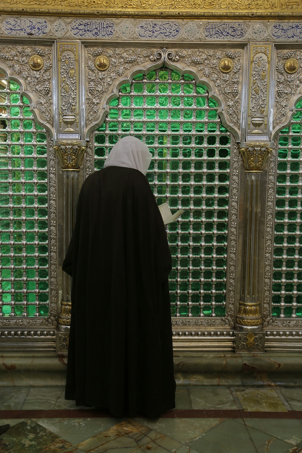 a person standing in front of a green glass wall