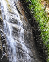 Beautiful waterfall cascading down rocks with clear water in Sentul nature.
