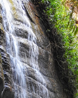 Beautiful waterfall cascading down rocks with clear water in Sentul nature.