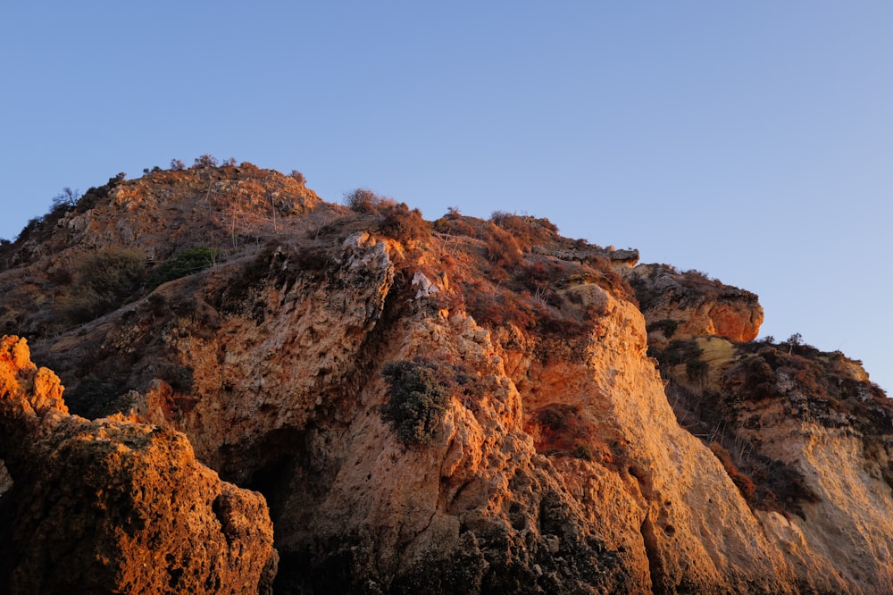 a rocky mountain with a clear blue sky in the background