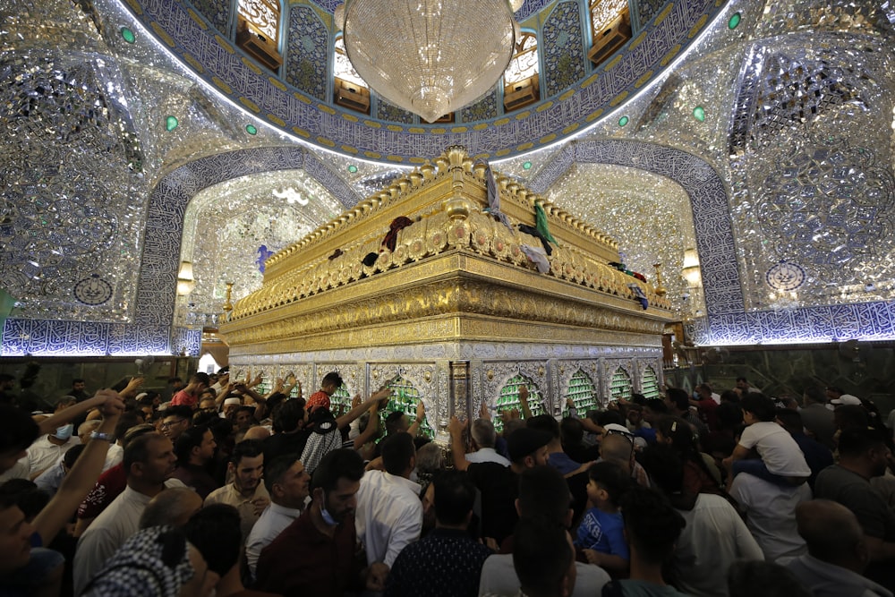 a crowd of people standing around a golden shrine