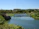 A smiling guest enjoying a peaceful moment by the river near the eco-lodge.