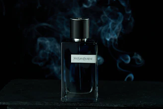 A dark, elegant perfume bottle with woody accents surrounded by cedar and amber.