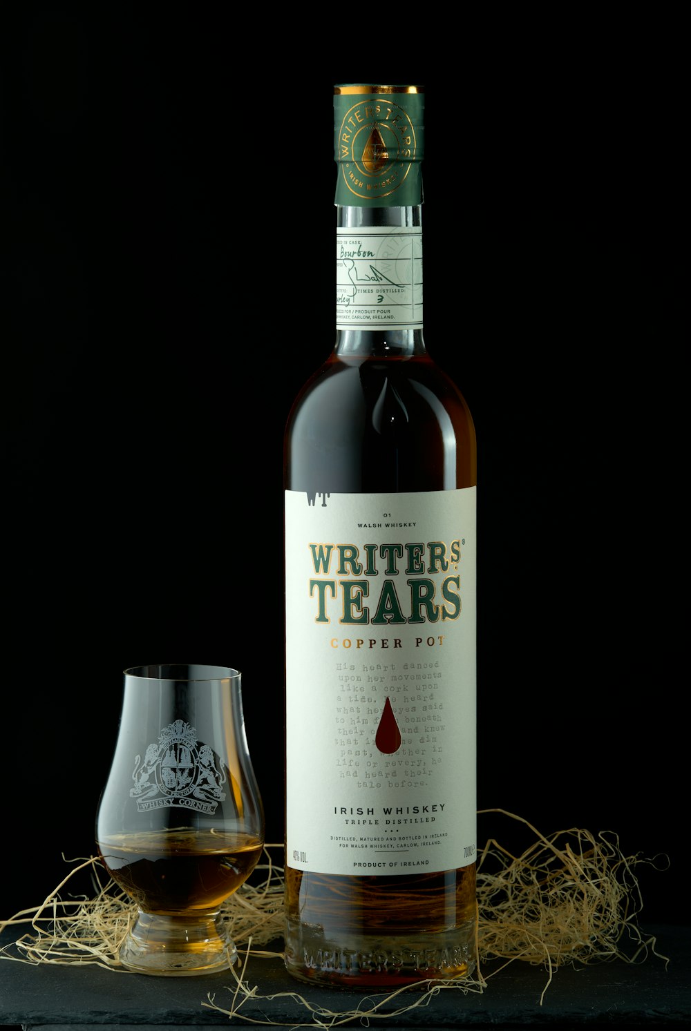 una bottiglia di whisky seduta accanto a un bicchiere