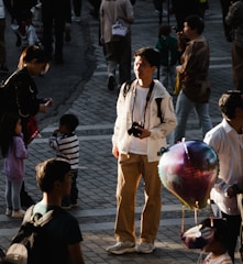 A candid shot of Prem Young filming a vibrant street scene with a handheld camera.