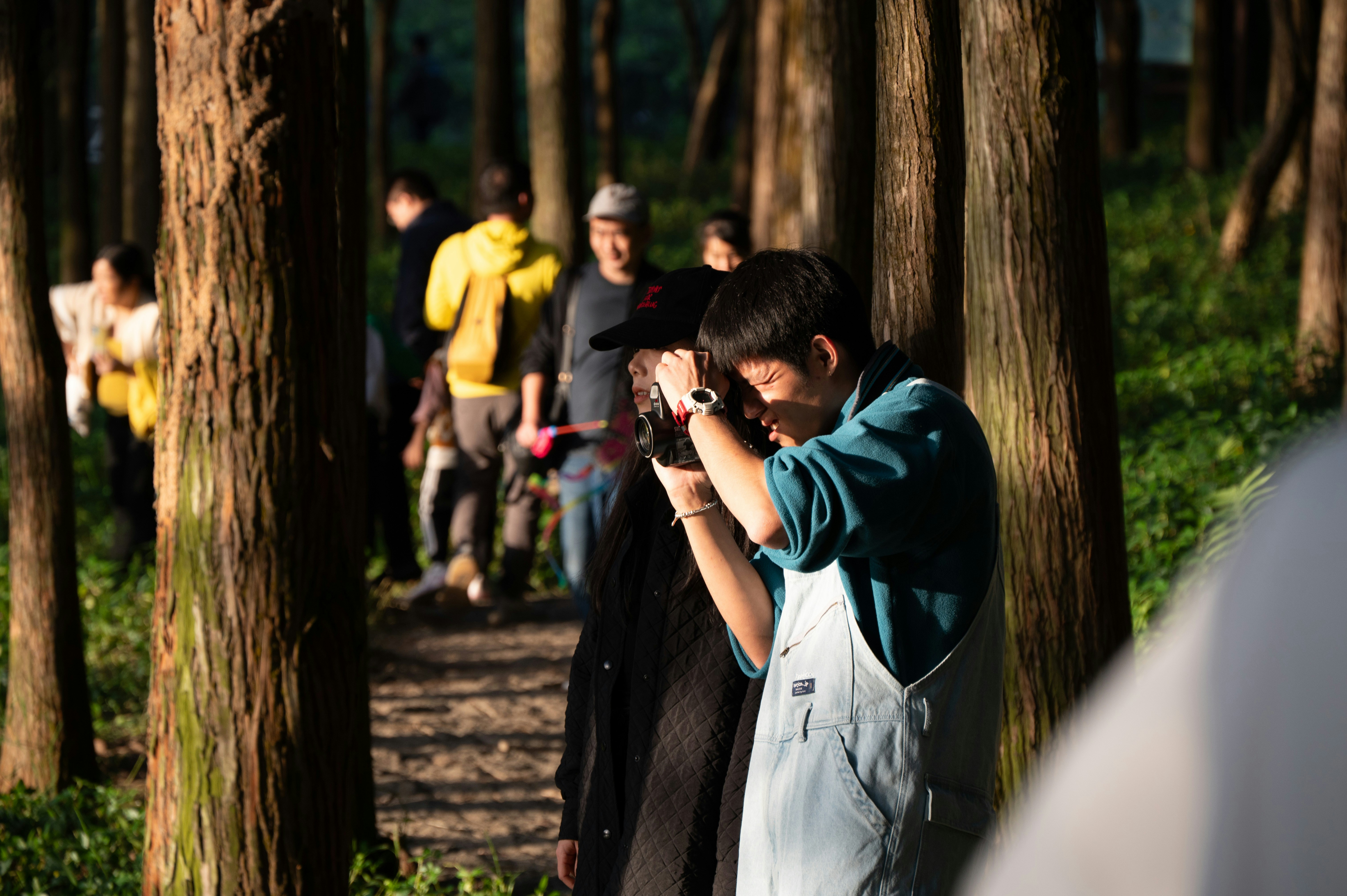 a man taking a picture of a group of people in the woods