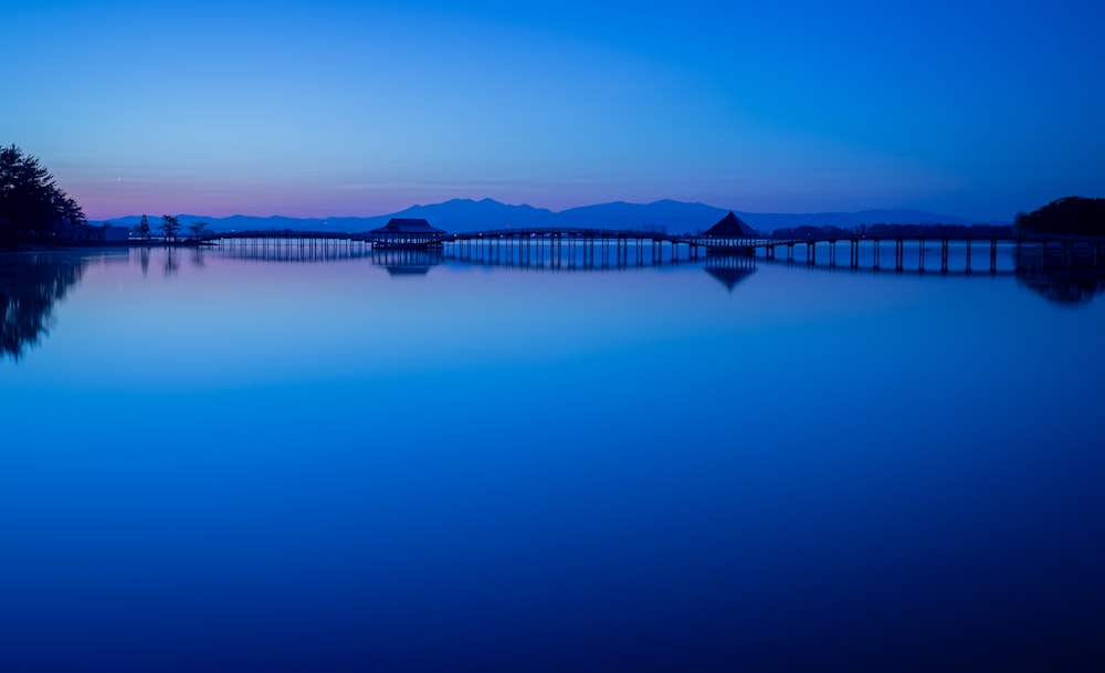 a large body of water with a bridge in the background