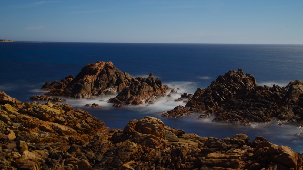 a view of a rocky coastline with waves coming in