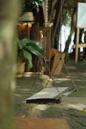 Rustic wooden swing in a blooming garden under a sunny sky