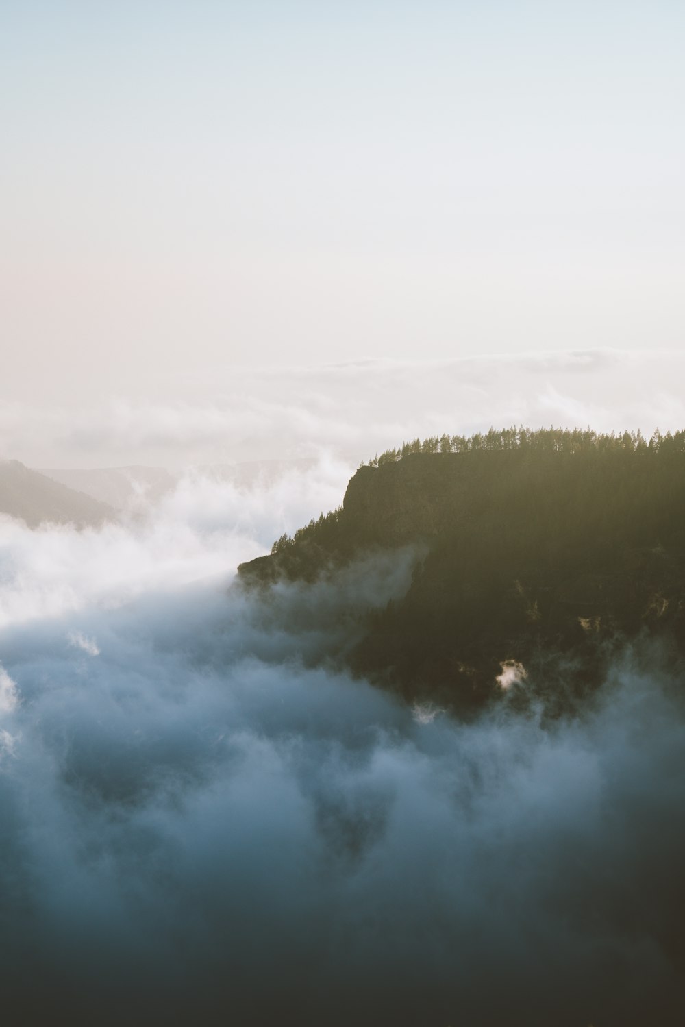 a small island in the middle of a sea of clouds