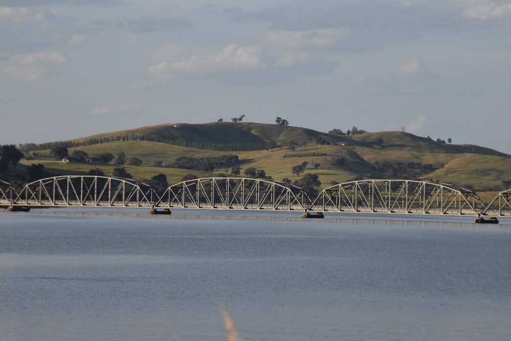 a bridge over a body of water with hills in the background