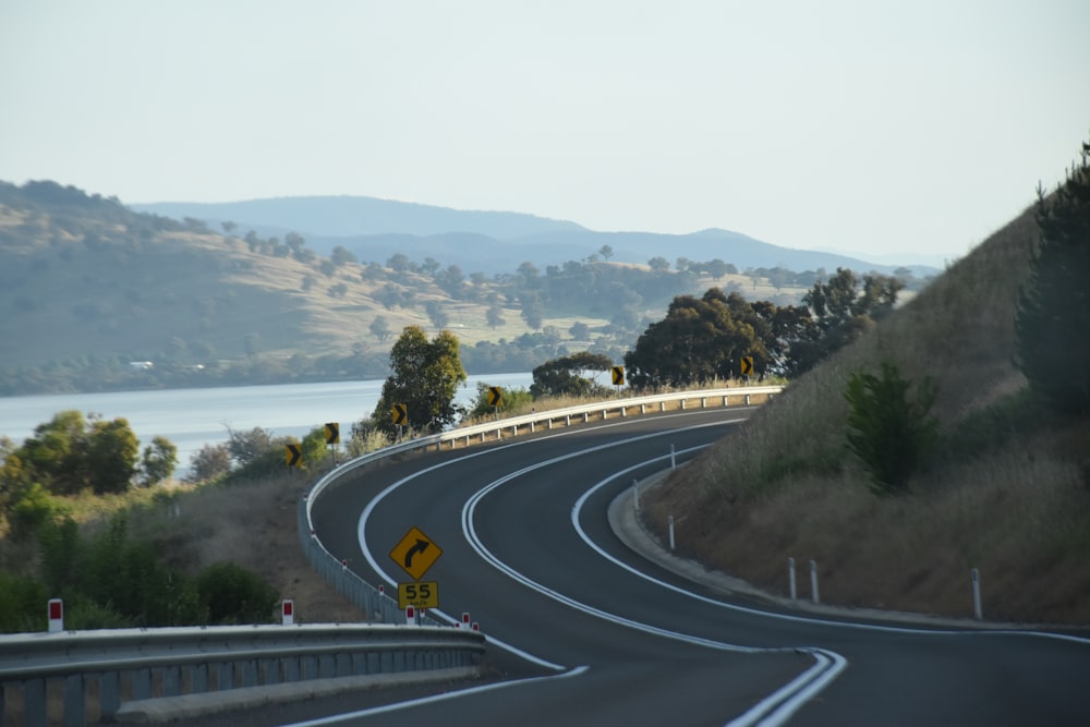 a curved road with a sign on the side of it