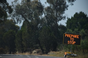 Traffic management team setting up mobile signage on a busy road construction site