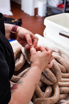 a person holding a sausage in their hands