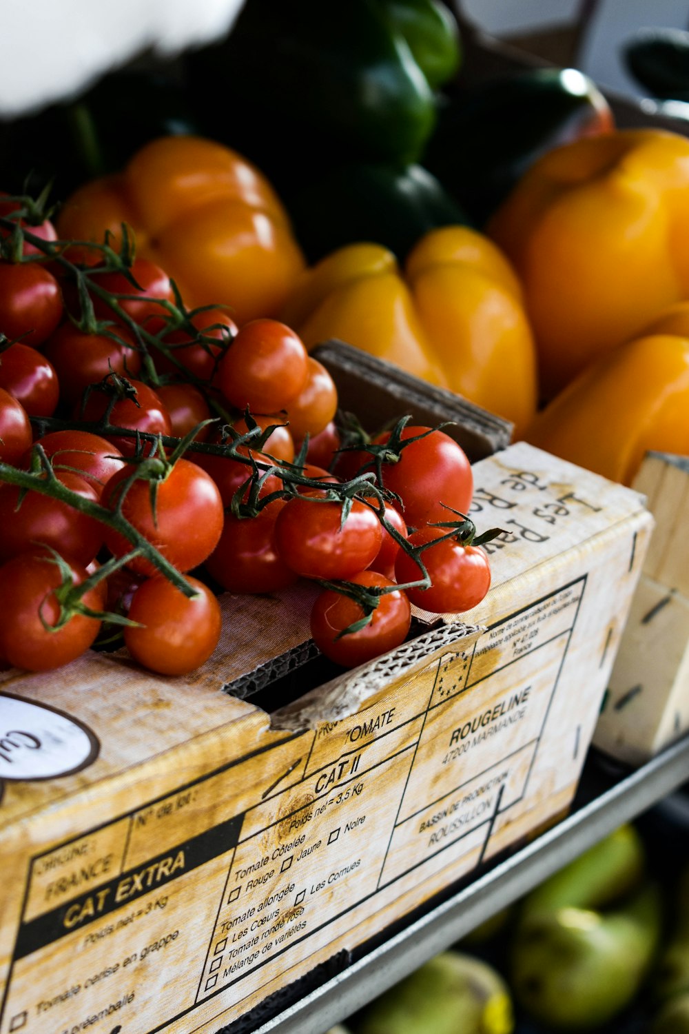 a crate of tomatoes and other fruits and vegetables