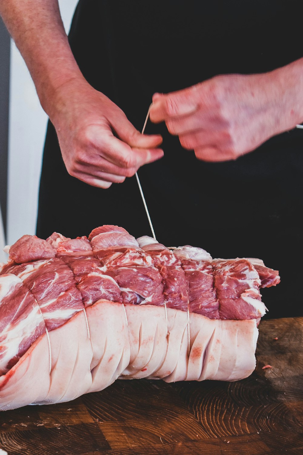 a person cutting up meat on a cutting board