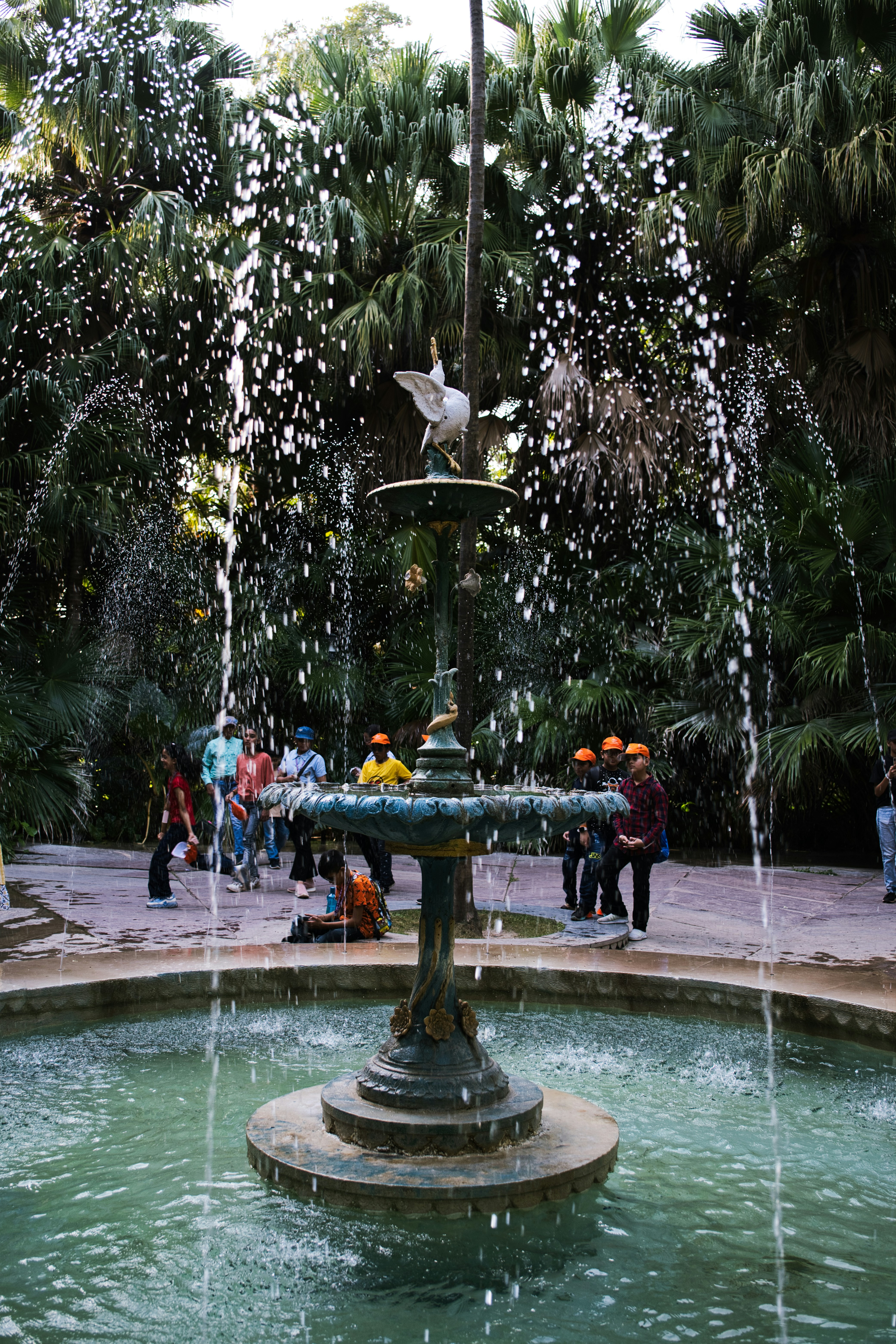 a group of people standing around a fountain