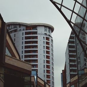 a tall white building sitting next to a traffic light