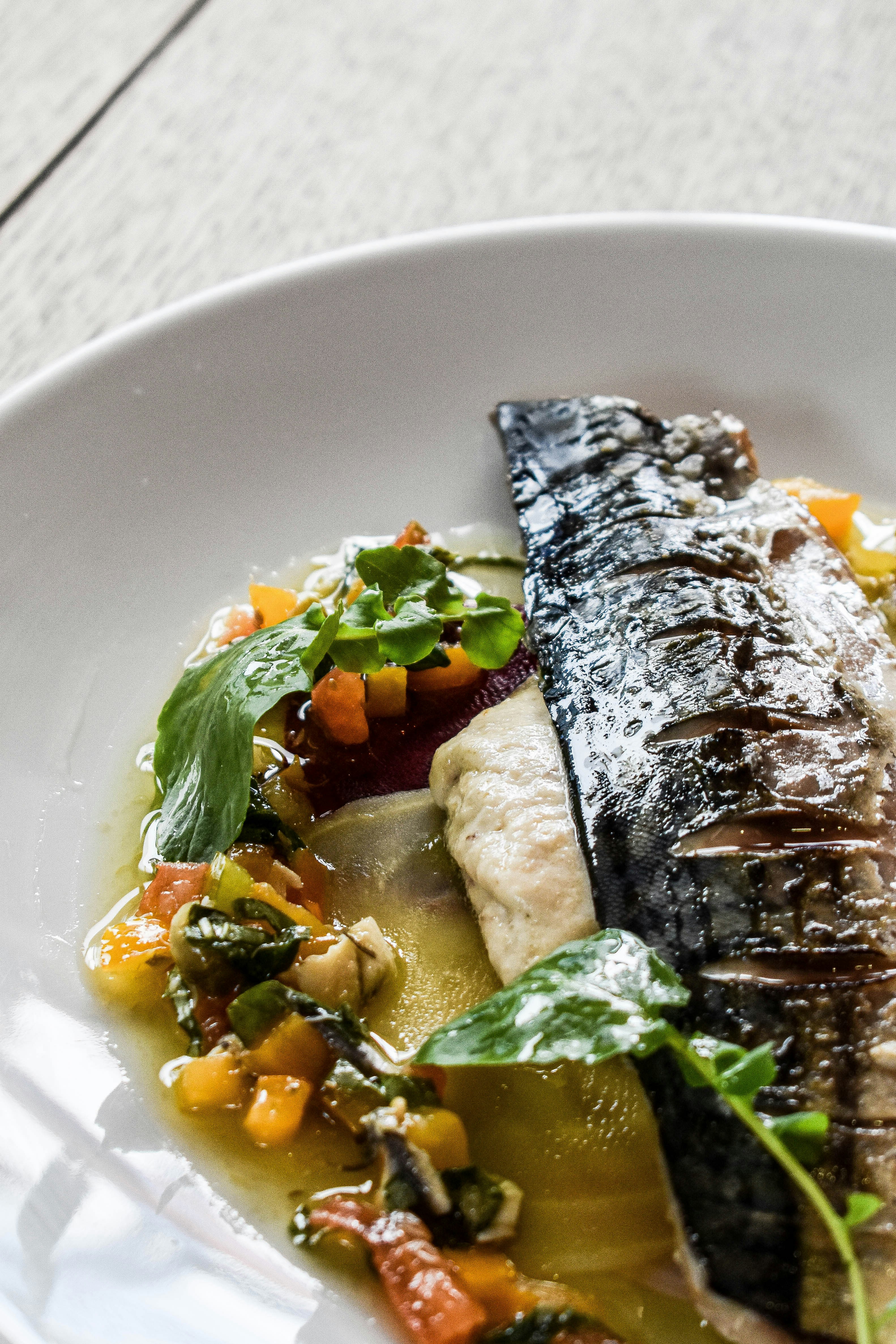a white plate topped with fish and vegetables