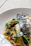 Close-up of a beautifully grilled fish plated with fresh lemon slices and herbs.