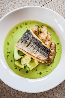 a white bowl filled with food on top of a wooden table