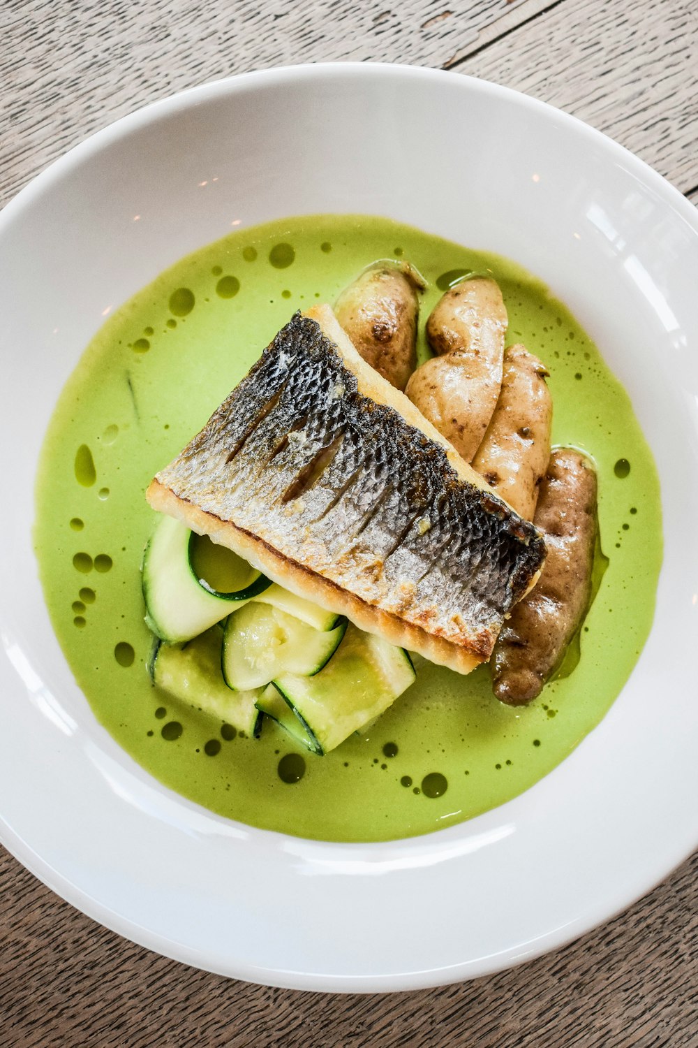 a white bowl filled with food on top of a wooden table