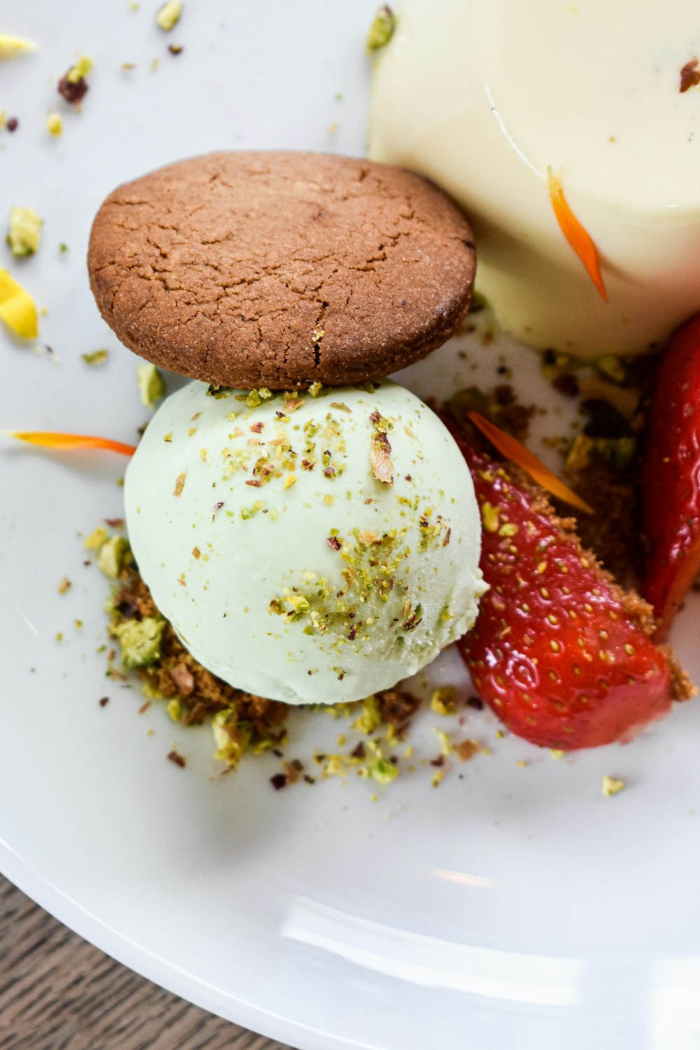 a white plate topped with ice cream and a cookie