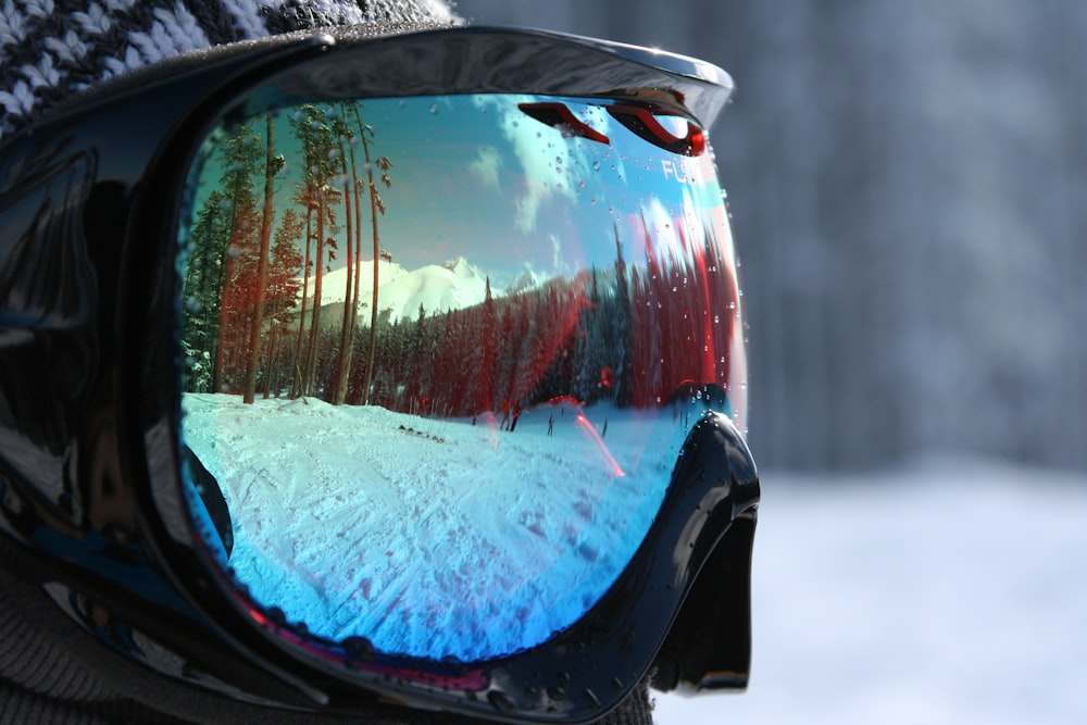 the reflection of a person in a pair of ski goggles