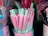 A variety of pastel-colored pens are displayed in a container. The pens are predominantly pink and mint green, with some featuring illustrations of unicorns. The container housing the pens also has pastel designs and unicorn graphics, adding to the whimsical and playful theme.
