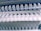 Several spiral-bound notebooks are stacked on top of each other, showcasing the loops of white wire binding against the white and blue edges of the covers.