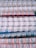 Stacked spiral-bound notebooks with alternating white, red, and blue rings. The notebooks have visible pages with lined paper and a variety of colored covers.