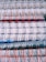 Stacked spiral-bound notebooks with alternating white, red, and blue rings. The notebooks have visible pages with lined paper and a variety of colored covers.