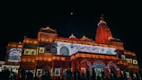 Nighttime view of a temple illuminated with traditional lamps during a major Hindu festival.