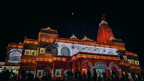 Nighttime view of a temple illuminated with traditional lamps during a major Hindu festival.