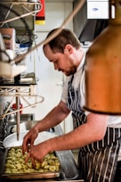 a man standing over a pan filled with food