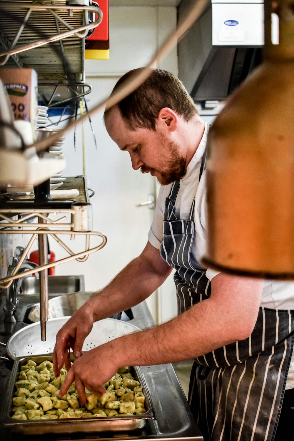 a man standing over a pan filled with food