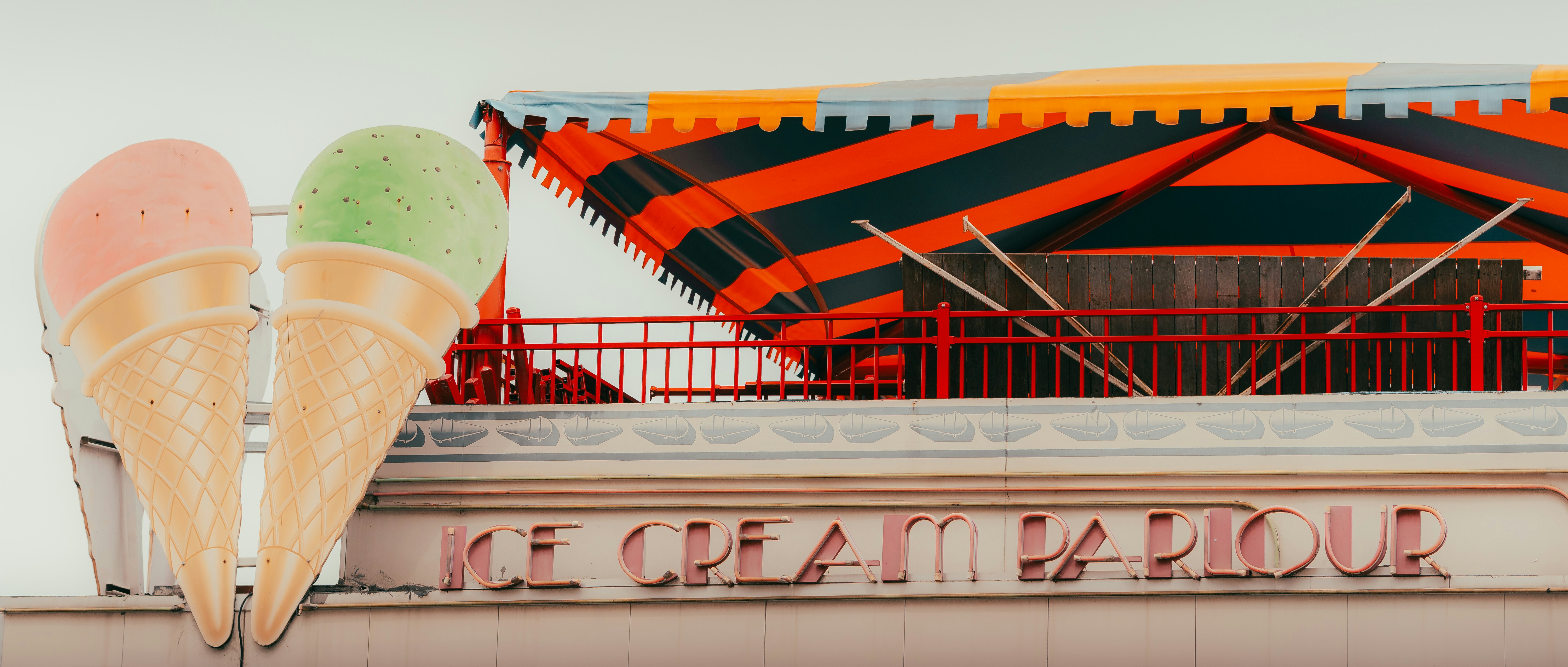 an ice cream shop with an orange and green umbrella