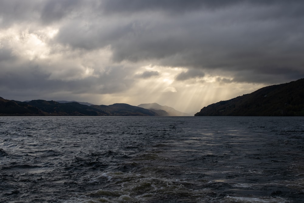 a body of water with mountains in the background