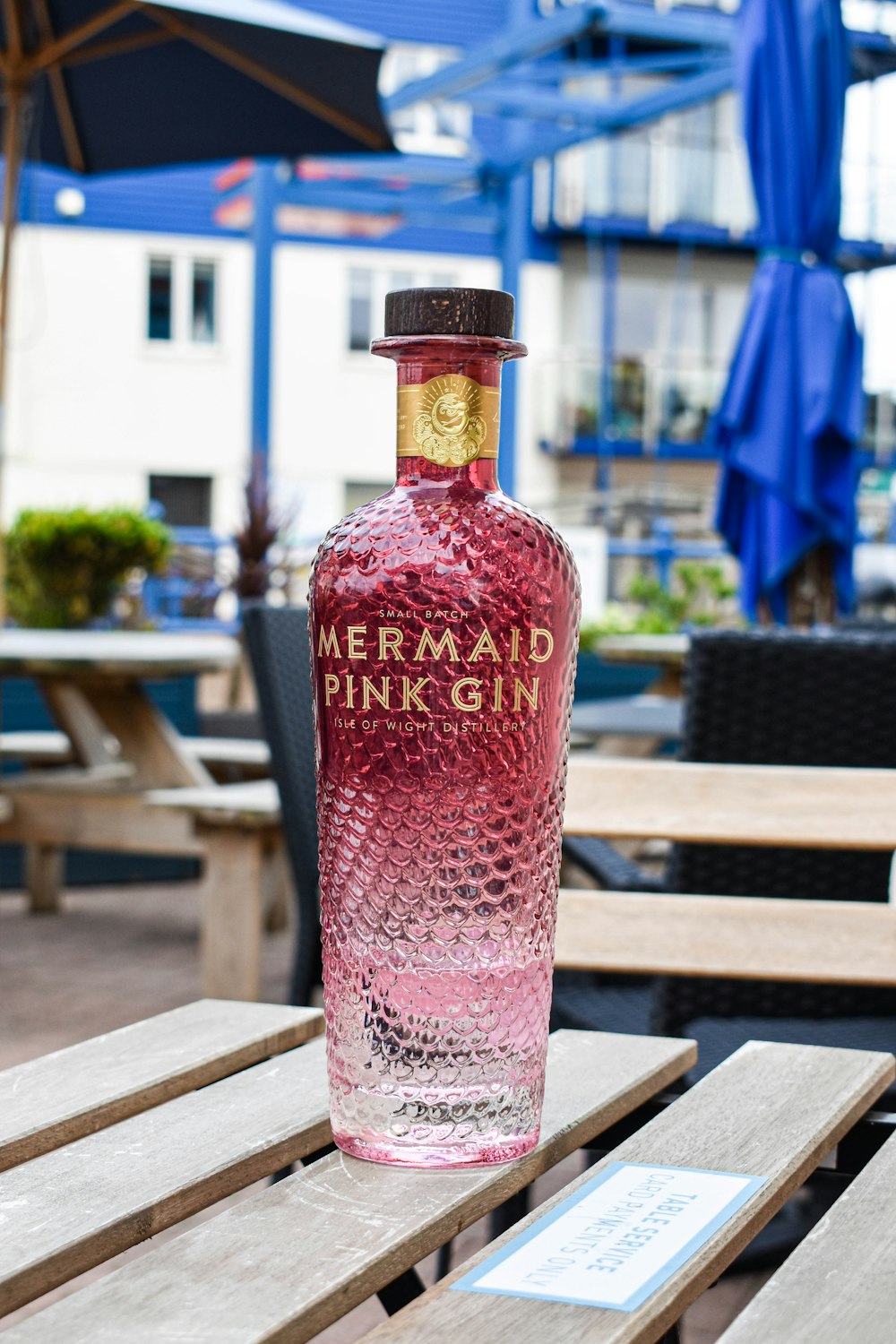 a bottle of pink gin sitting on top of a wooden table