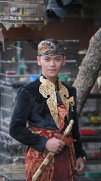 a man in a costume standing in front of a bird cage