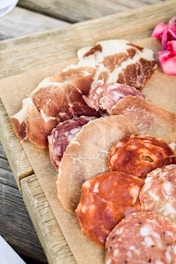 a wooden cutting board topped with different types of meat
