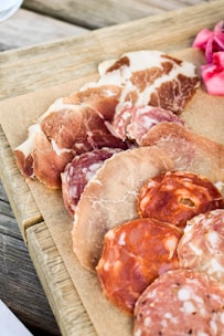 a wooden cutting board topped with different types of meat