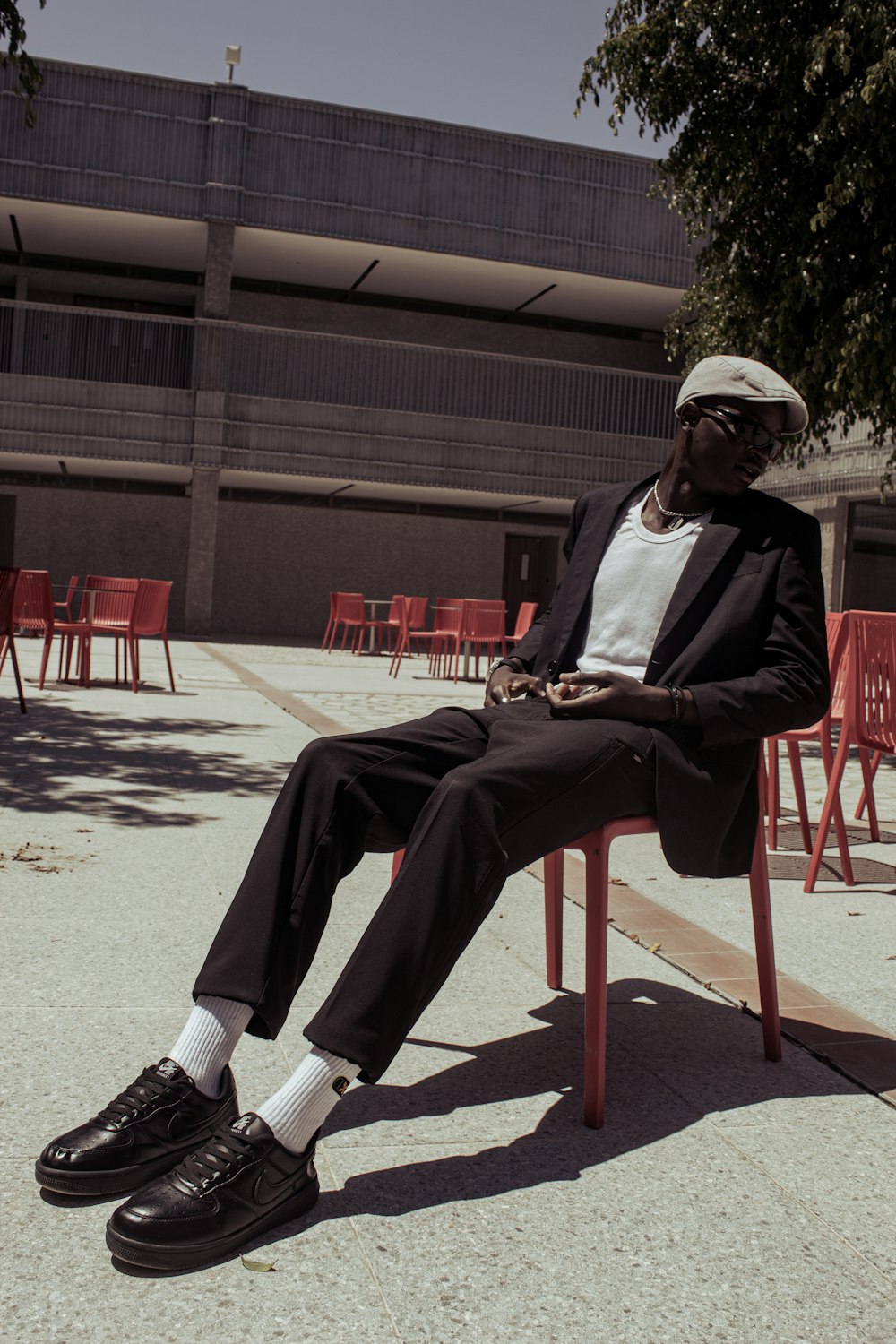 a man in a suit and hat sitting on a chair