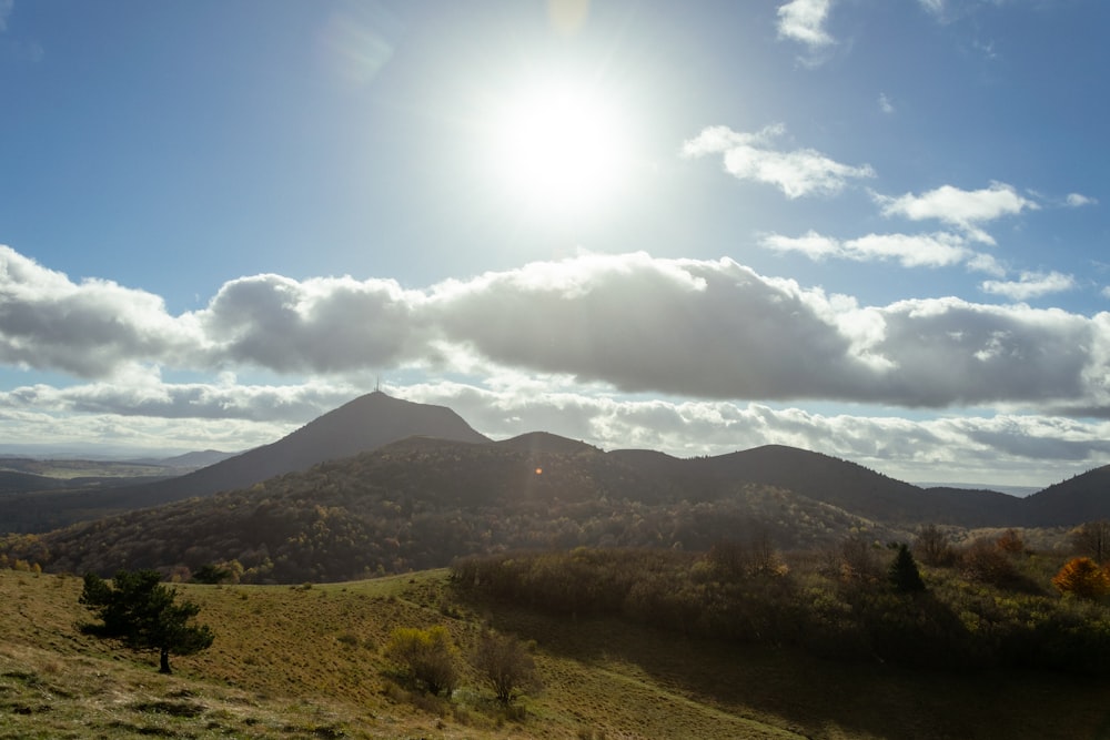 the sun is shining over the mountains in the distance