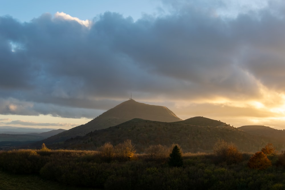 the sun is setting over a mountain range