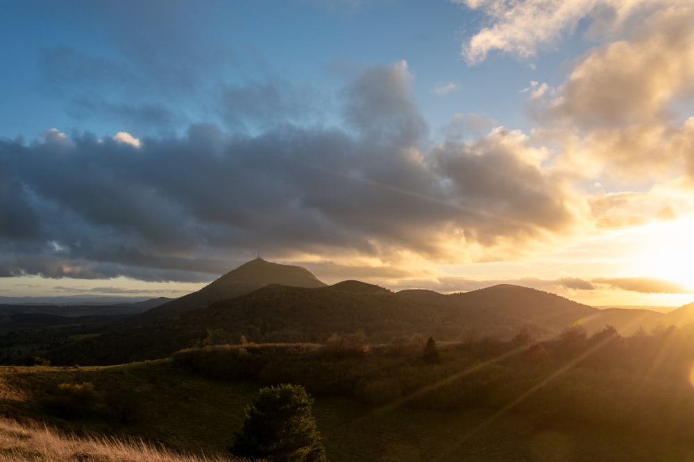 the sun is setting over a mountain range