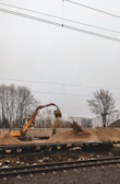 An excavator carefully handling contaminated soil for processing.