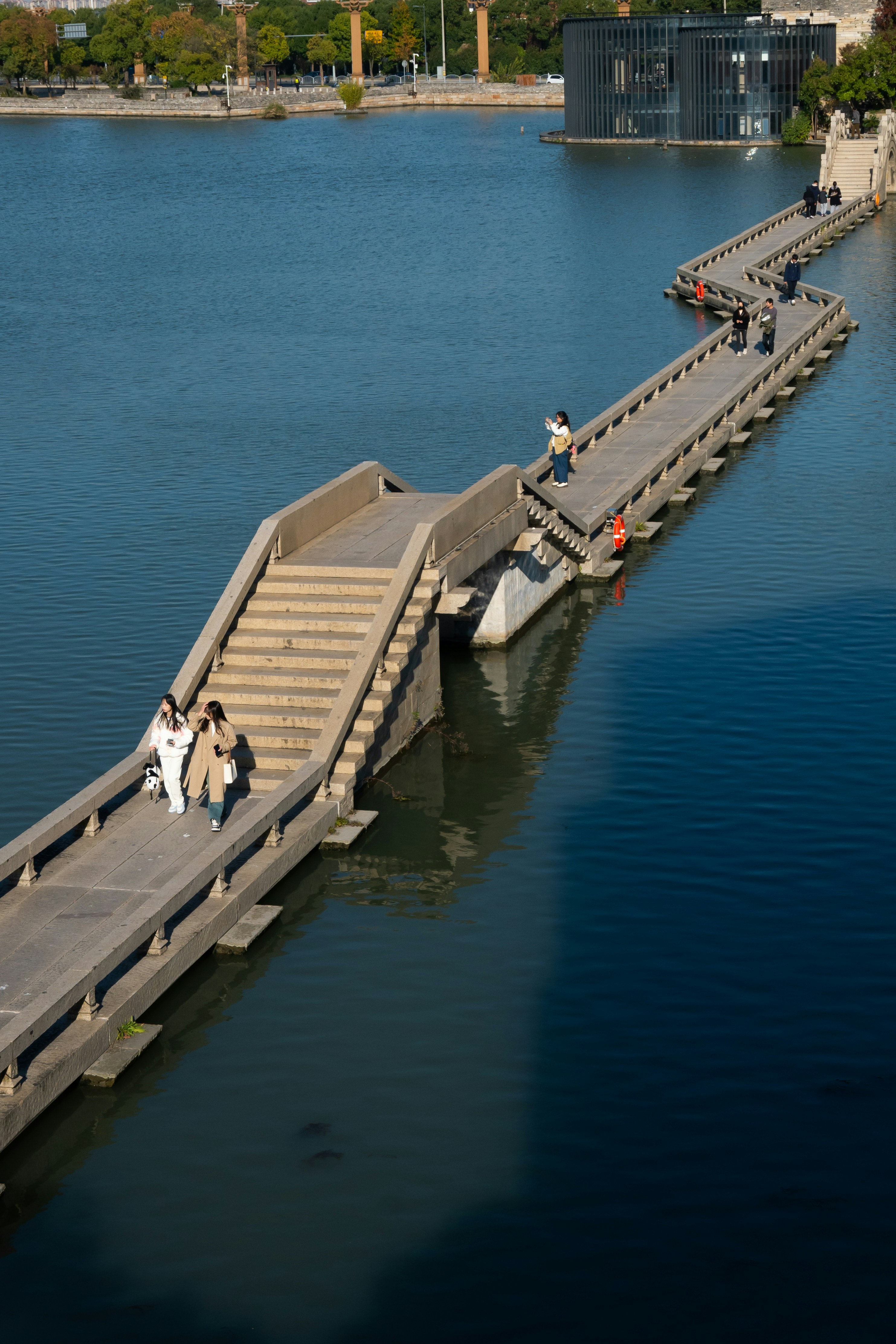 A group of people walking across a bridge over a body of water photo ...