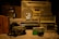 A collection of vintage items including radios, cameras, and a clock. The central focus is on an old boombox with large speakers. Beside it, there are classic film cameras and a brightly colored analog radio. A decorative clock with a panda design is also visible, adding a nostalgic feel to the scene.