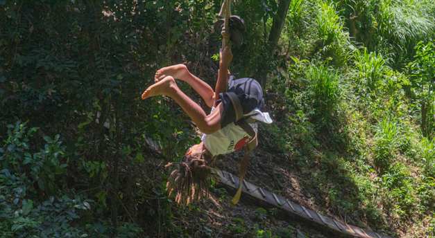 a person hanging upside down on a rope